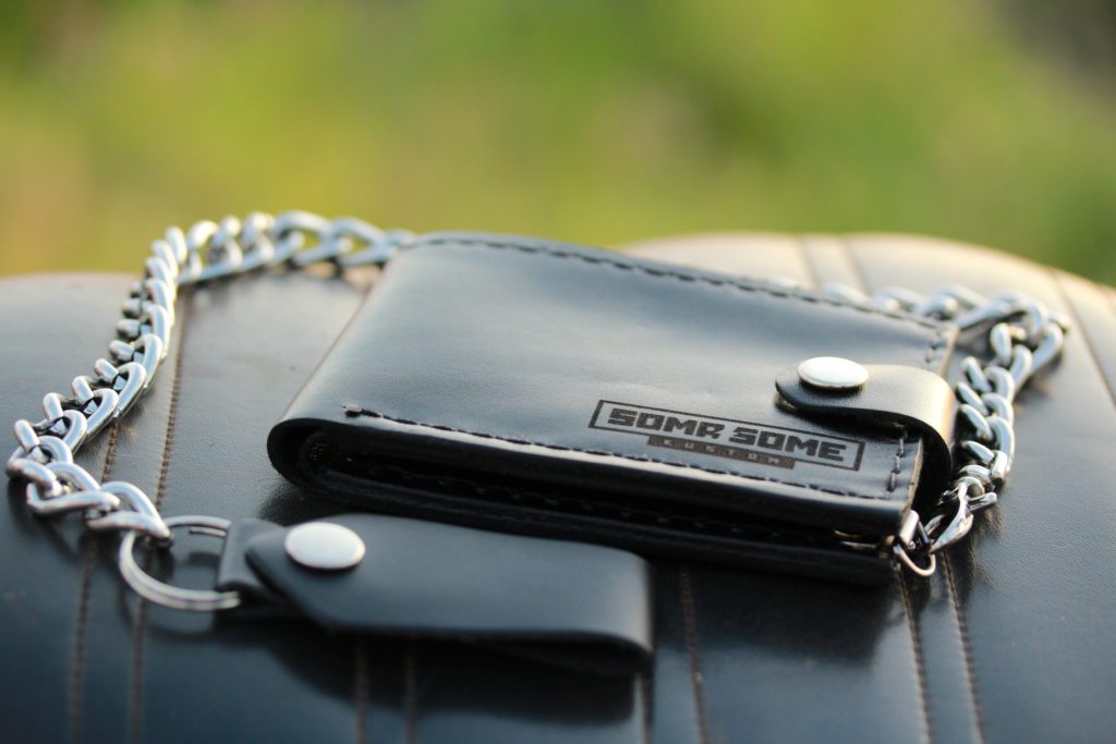 Carteira de couro preta com corrente de metal prateada