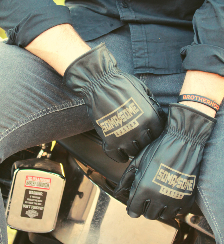 Luvas de couro com a marca Soma du Some Kustom em cima de uma moto Harley-Davidson