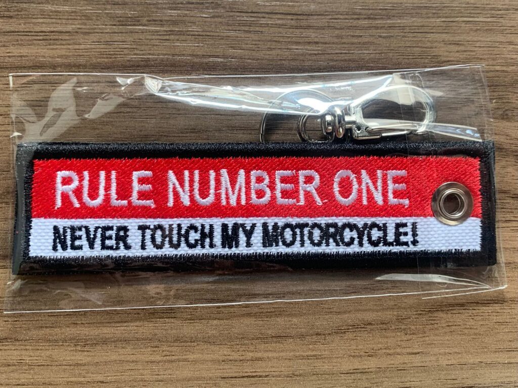 Chaveiro bordado com a frase 'RULE NUMBER ONE, NEVER TOUCH MY MOTORCYCLE!'