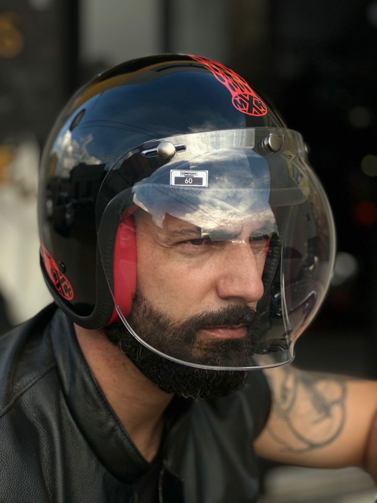 Homem barbudo usando capacete preto com viseira transparente